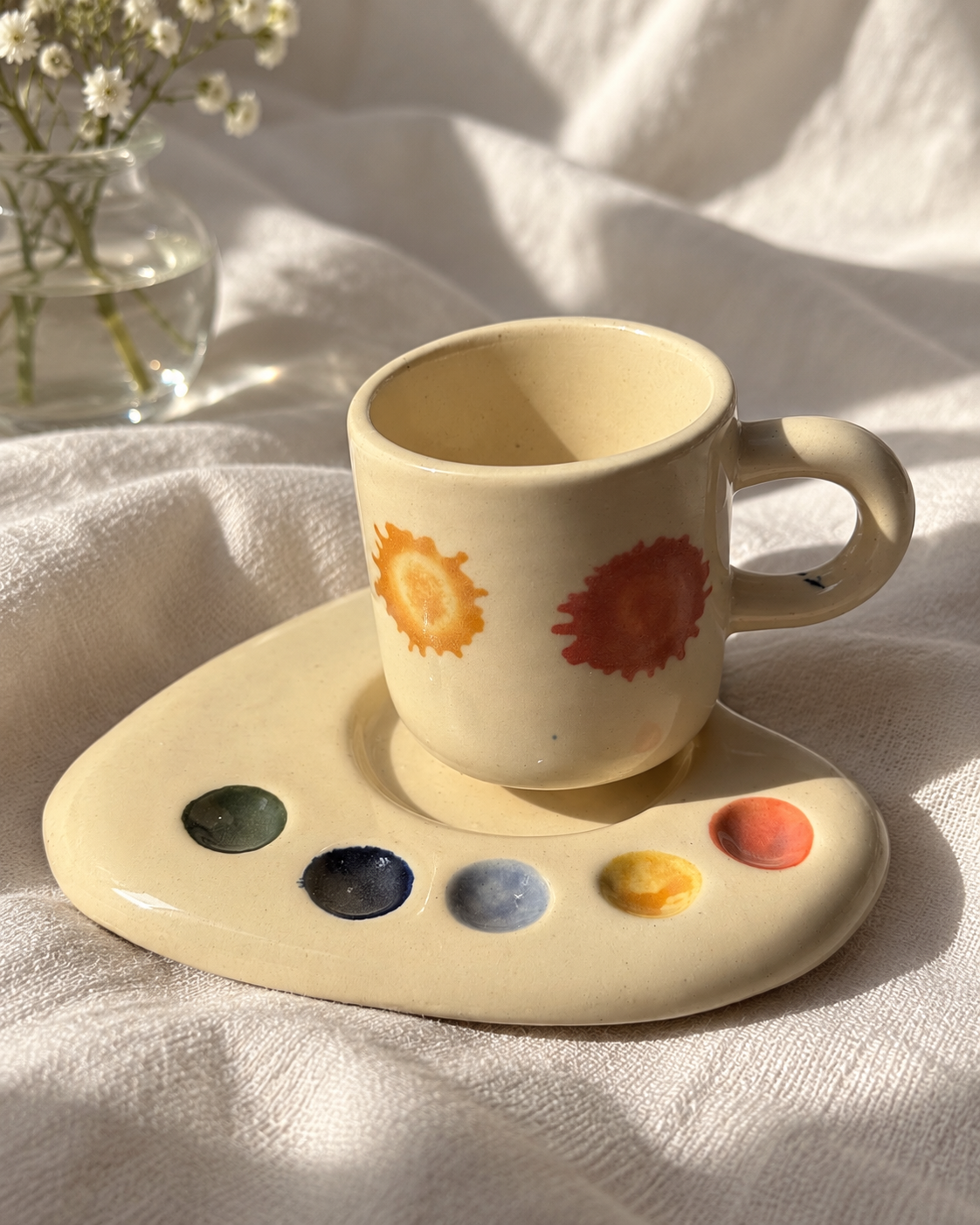 Cream espresso mug with colourful paint details on a matching artist palette saucer