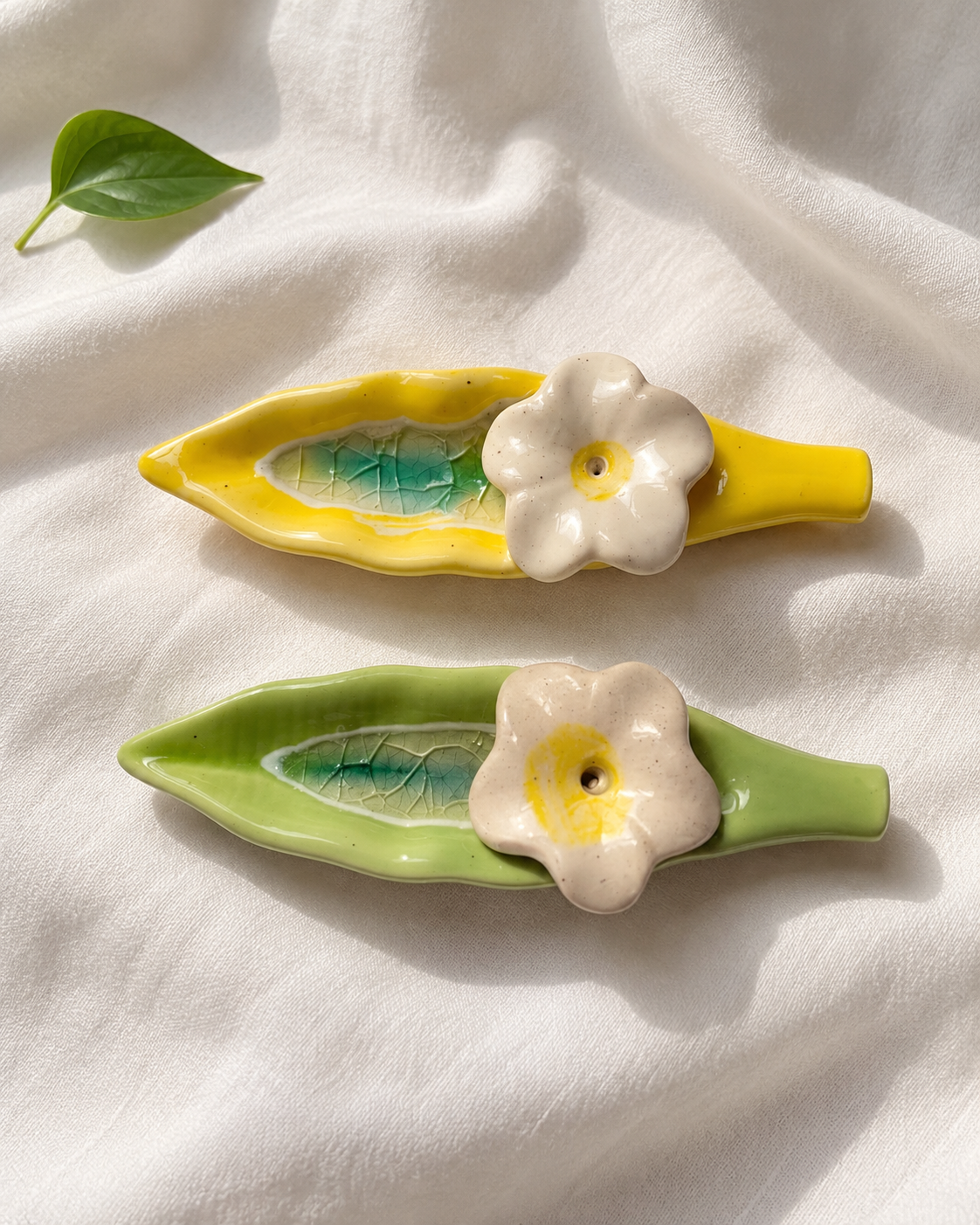 Leaf and Flower Ceramic Incense Holders - Yellow and Green, Set of 2, displayed on fabric