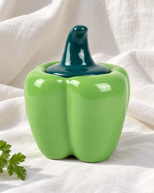 Green Capsicum Ceramic Pickle Jar - 500 ml, displayed on fabric