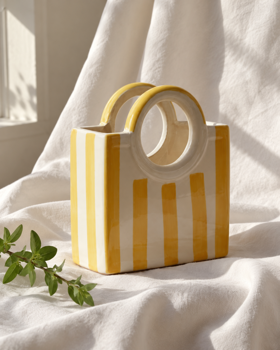 Yellow Striped Ceramic Basket Vase, displayed on fabric