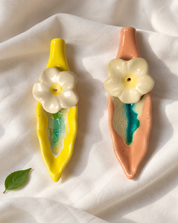 Leaf and Flower Ceramic Incense Holders - Yellow and Pink, Set of 2, displayed on fabric
