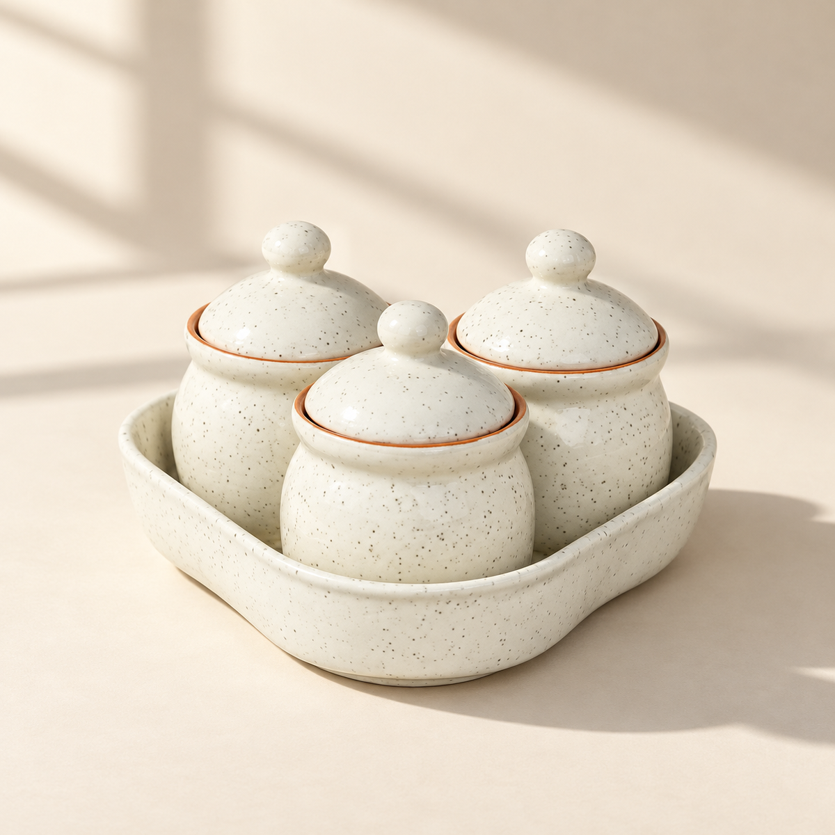 Speckled White Ceramic Jar Set of 3 with matching lids and tray on a plain ivory backdrop