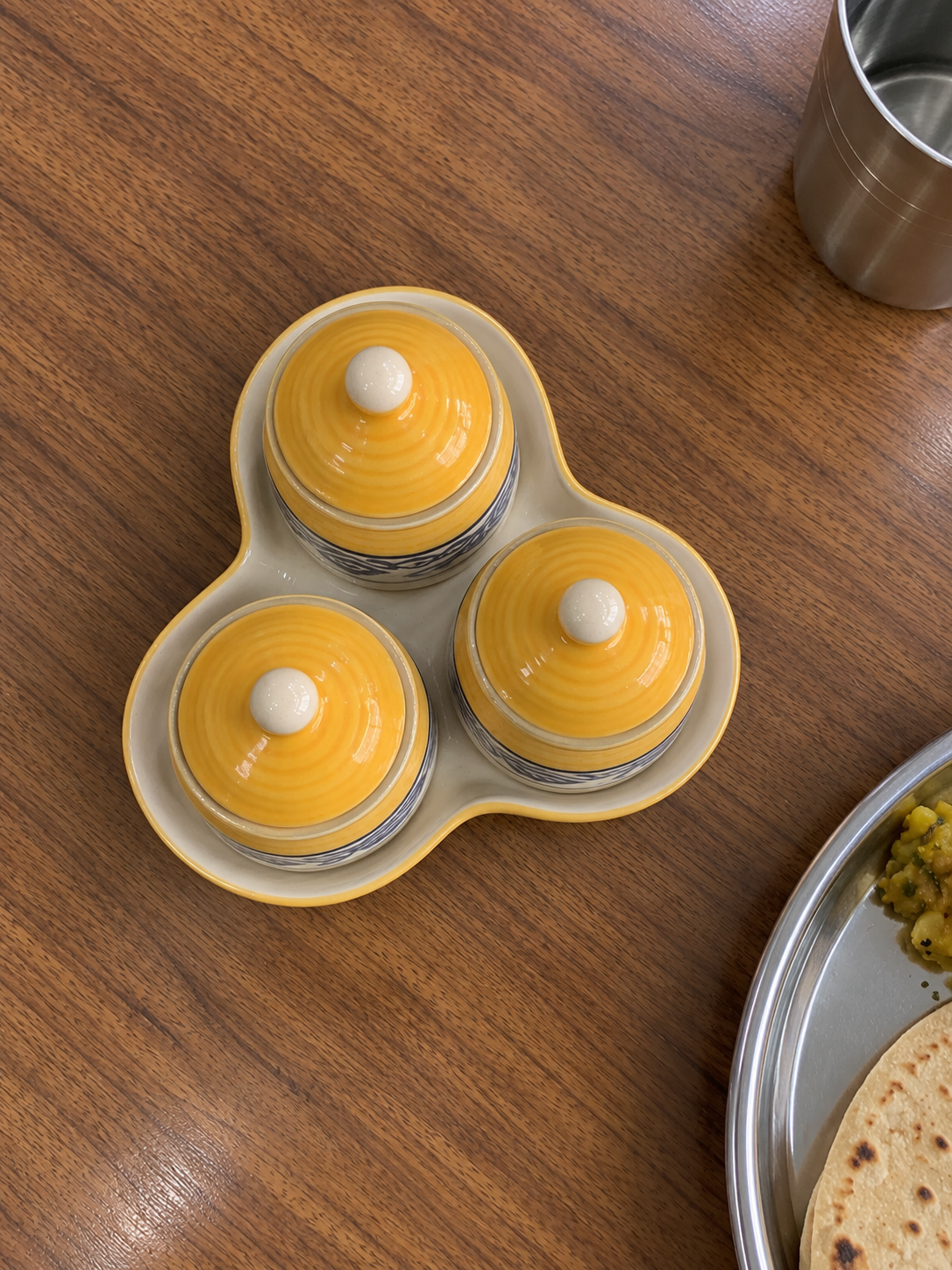 Yellow Floral Ceramic Jar Set of 3 — overhead view on a dining table